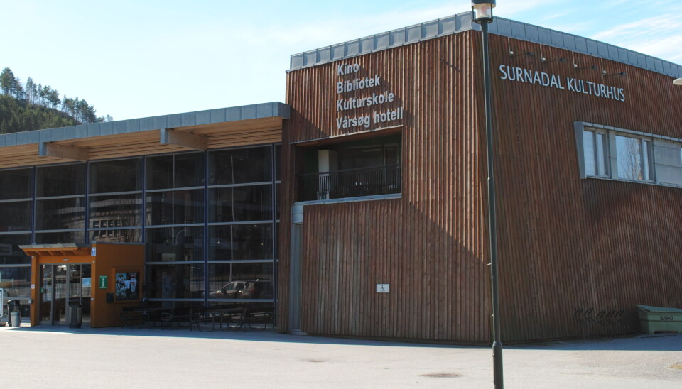 Nytt frå Surnadal Kulturhus Bilde av et brunt bygg med store glassvinduer og på siden står det 'SURNADAL KULTURHUS'