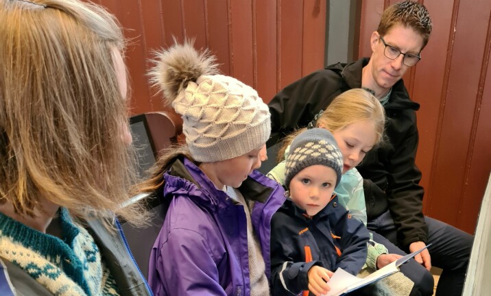 Johan Svanem Halgunset åpner 4-årsboka i lag med familien sin.