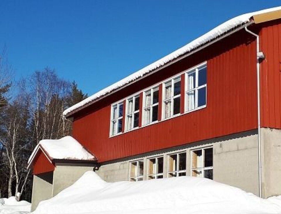 Juletrefest fjerde juledag i Lomunda grendehus Ett rødt hus i to etasjer med snø rundt, og 'Lomunda grendahus' på veggen.