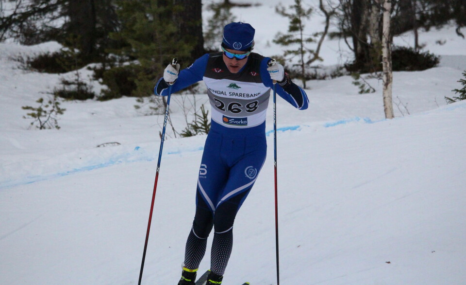 Jonas Aasbø En mannlig skiløper i blå drakt i løypa med startnummer på brystet.