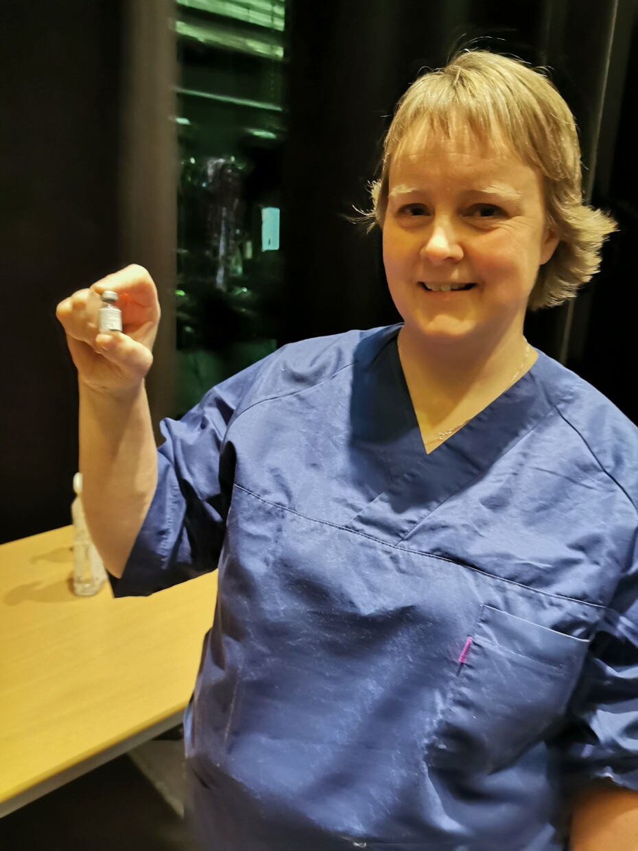 Historisk. Berit Moan Møkkelgård viser fram det første glasset med koronavaksine som er brukt i Surnadal
