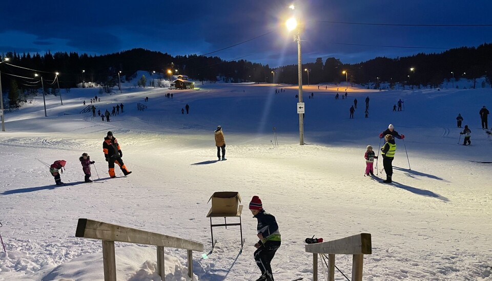 Barn i løypa Mange barn som går på ski på en skiarena.
