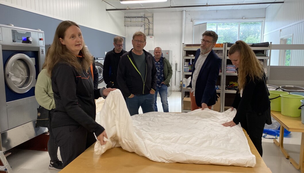 Grete Elshaug viser fram ei dyne fra bediftsnaboen Ullkorga. De skal finne ut hvor kraftig vask dyna tåler. Grete Elshaug viser fram ei dyne fra bediftsnaboen Ullkorga. De skal finne ut hvor kraftig vask dyna tåler.