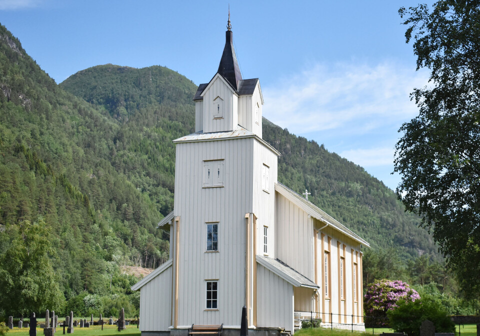 Todalen kyrkje Ei kyrkje bygd av tre. Grønt gras på kyrkjegarden og fjell i bakgrunnen.