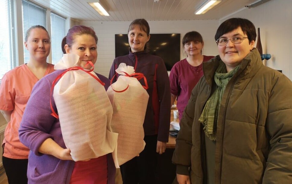 May Kristin Bye Halgunset med overraskelseskomiteen, som er kolleger hos Elshaug renhold, og ordfører Vibeke Langli. May Kristin overbringer den ene blomsten til datteren Lena.