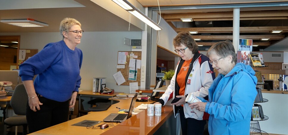 Kjellaug Foseide og Inger Kjelås henter sin fjelltrimmenkrus på biblioteket hos Kari Mette Skjølsvold, som er daglig leder på Rindalshuset.