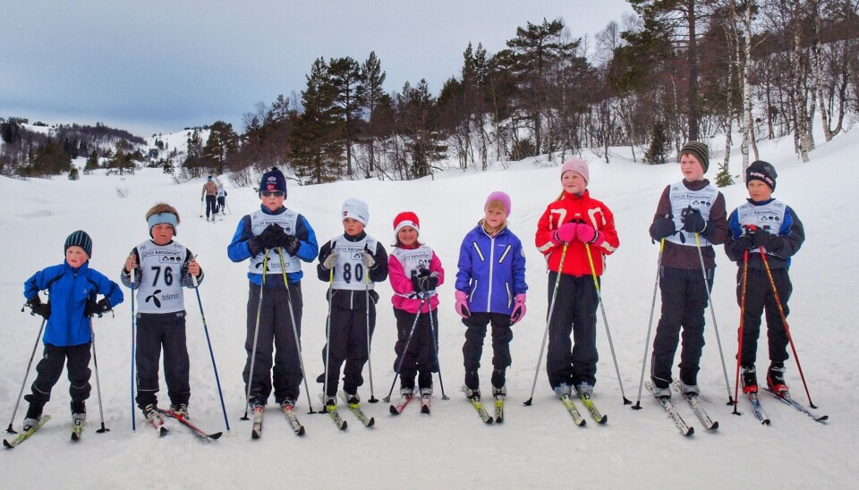 Flere barn på ski med startnummer, oppstilt ved siden av hverande.