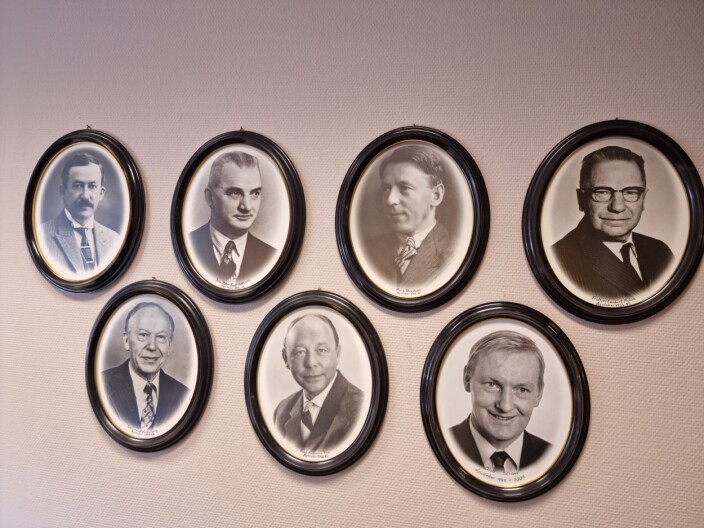 De tidligere apotekerne følger med fra kontorveggen. Far og bestefar Rolf Andreas Flo i midten på nederste rekke De tidligere apotekerne følger med fra kontorveggen. Far og bestefar Rolf Andreas Flo i midten på nederste rekke