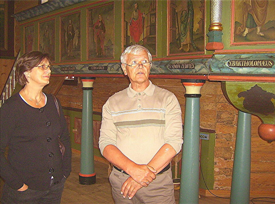 Randi Bøe får omvisning av Nils Erik Østerud i Dolstad-kyrkja i Mosjøen, der Kolset har måla alle disiplane på preikestolgalleriet.