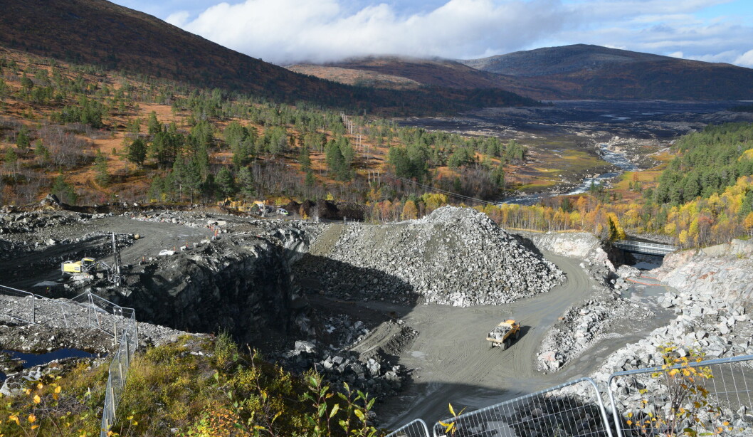 En blanding av løse fjellmasser og store steiner kjøres ut med dumper.