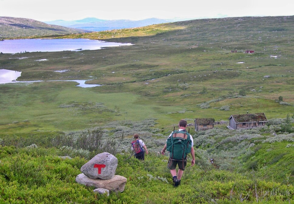 Gunnvor og Magne Bakken følger turistlina på tur ned mot Helgetunholtsetra. Rennslivatnet og Dørgehøtta i bakgrunnen. Sommaren 2003 gjekk dei Trollheimen på tvers. Dei starta ved Gjevilvatnet og gjekk heim til Rindal.