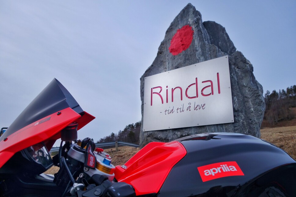 Eli Solvik er ein etter kvart erfaren motorsyklist, ivrig sjølvlært fotograf og dedikert rindalspatriot. Og har derfor sjølvsagt eit bilde av sin Aprilia med Tid til å leve-logoen i bakgrunnen.