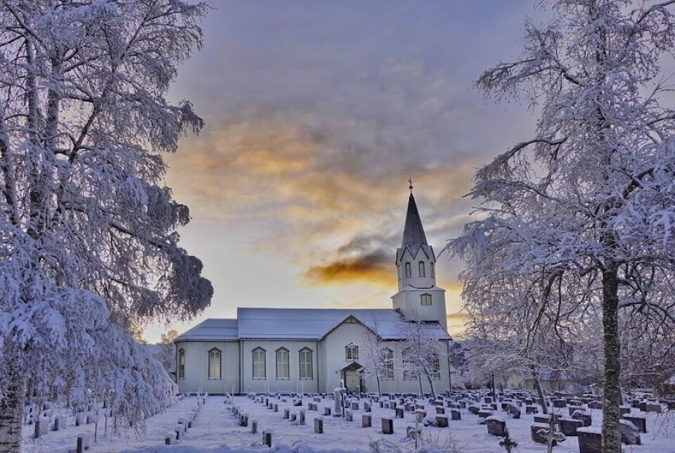 Rindal kirke med snø på kirkegården.