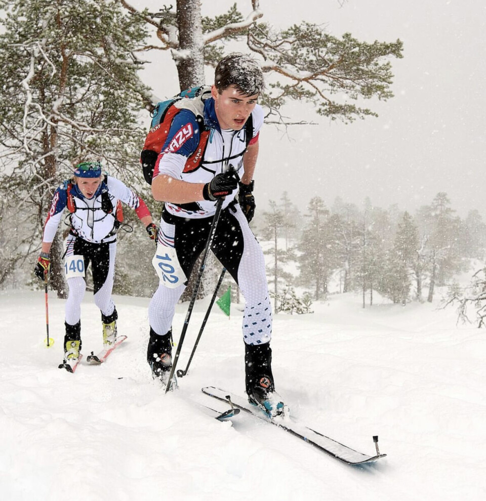 To skiløpere i randonee-utstyr på ski i lett snøvær