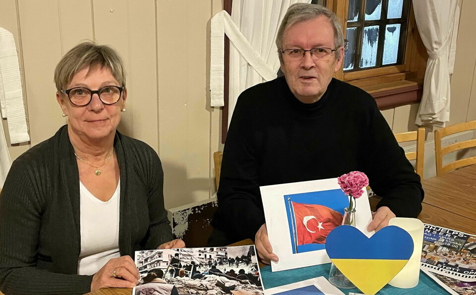 En kvinne og en mann holder opp ett bilde av et Tyrkias flagg, foran de står et hjerteformet Ukrainsk flagg.