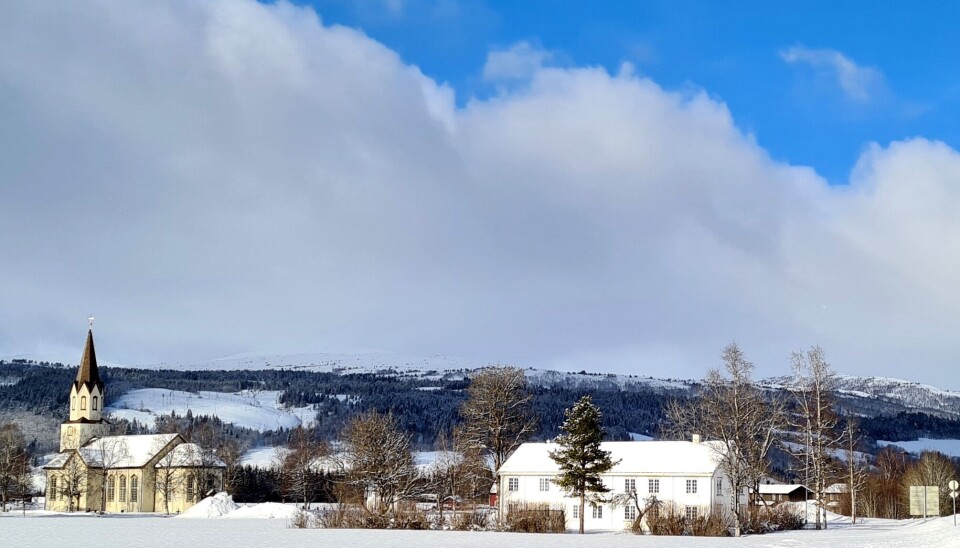 Rindal kirke og Rindal prestegard med langsida mot sør.