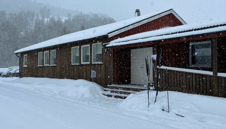 Et forsamlingshus. Det snør, og det står to apr ski og staver utenfor inngangen.