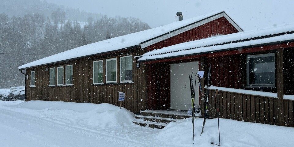 Et forsamlingshus. Det snør, og det står to apr ski og staver utenfor inngangen.