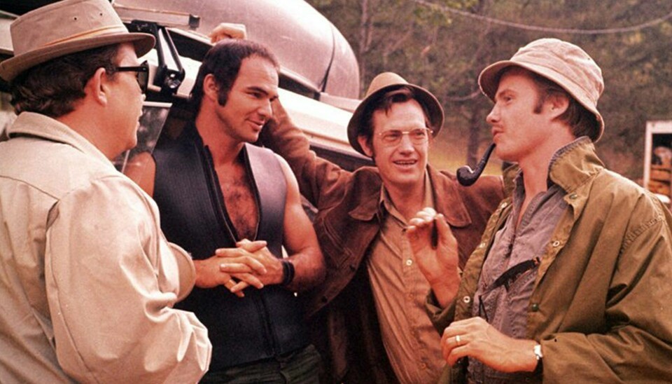 Bilde fra en scene i filmen 'Picnic med døden'
4 menn står ved en bil og prater sammen og smiler