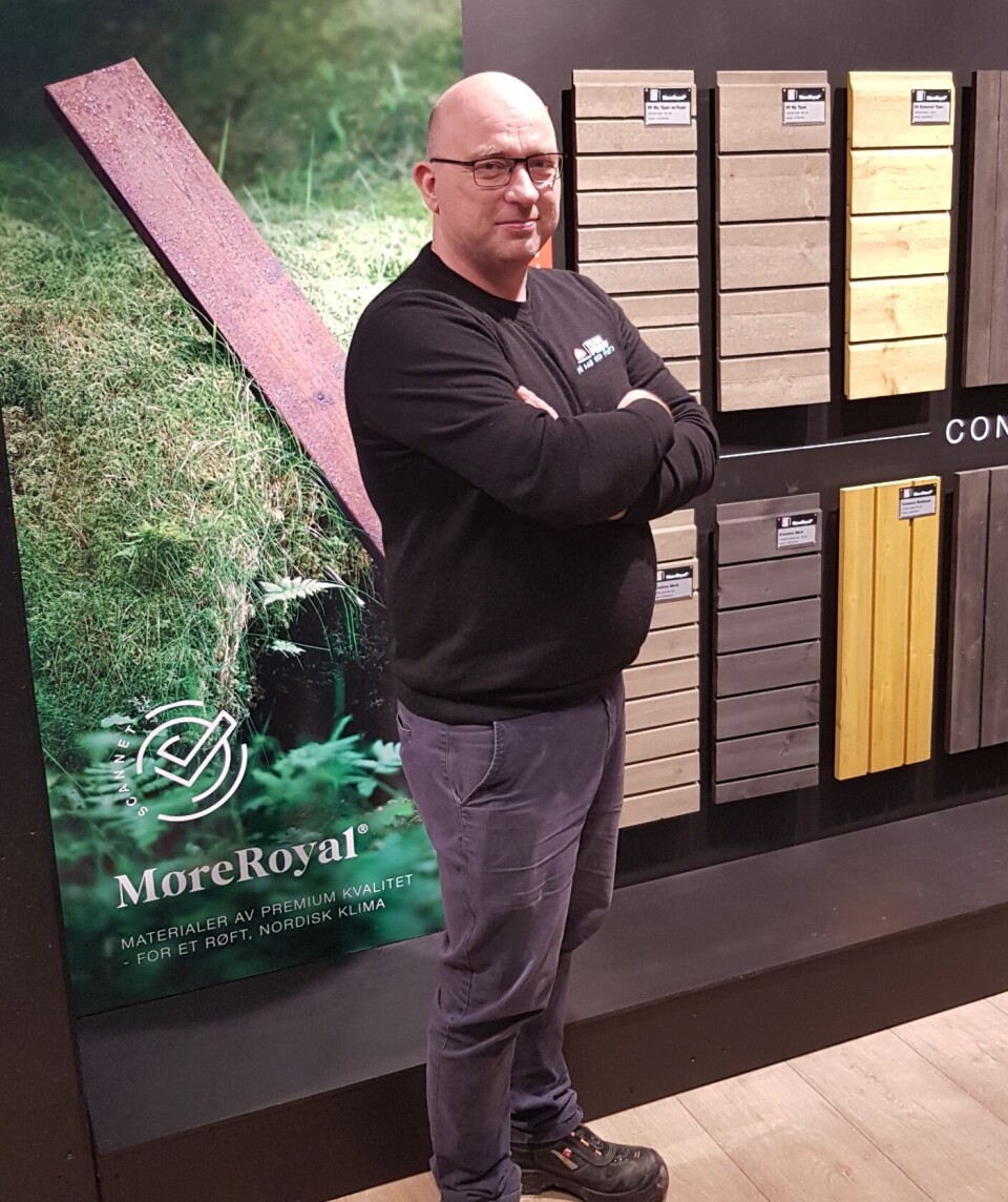 Konrad Våbenø Mann står med hendene i kryss foran vareprøver i kledning.