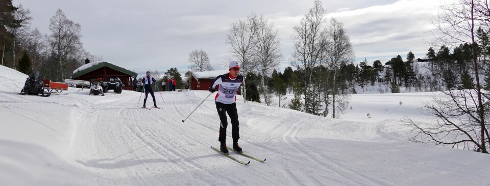 Skiløper i Rindal IL-drakt staker ut fra start.