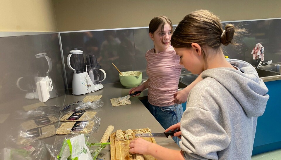 Skolelever jobber med mat på skolekjøkkenet