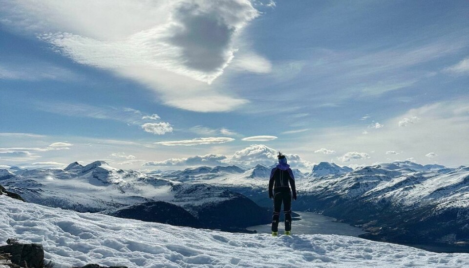 En kvinne står på fjellet og ser på utsikten