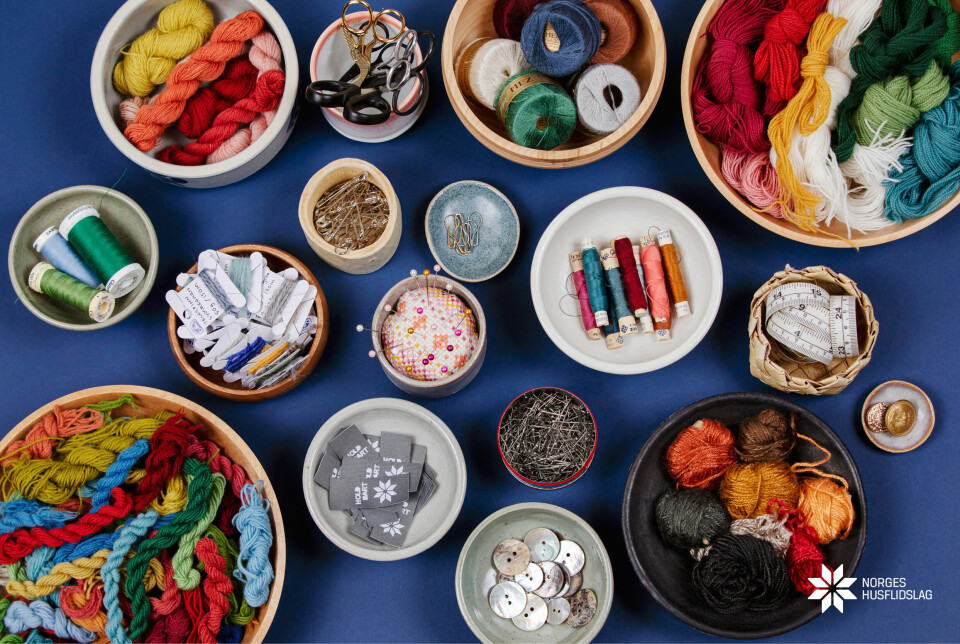 Bilde av masse sysaker i forskjellige farger som ligger i skåler på en blå duk