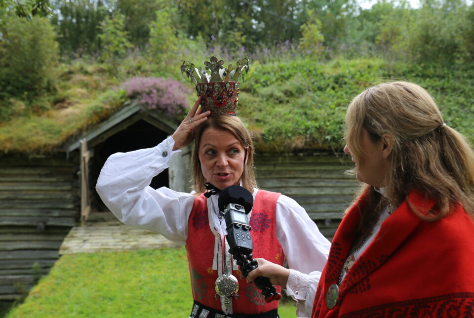En kvinne med Nordmørebunad og brudekrone blir intervjuet av en kvinne som holder en mikrofon