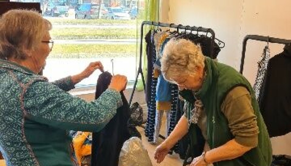To kvinner organiserer og henger opp klær