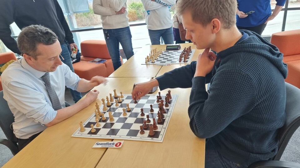 En mann og en ungdom spiller et slag sjakk mot hverandre