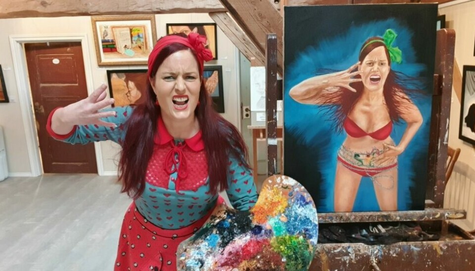 En kvinne poserer ved et selvportrett av seg selv som roper