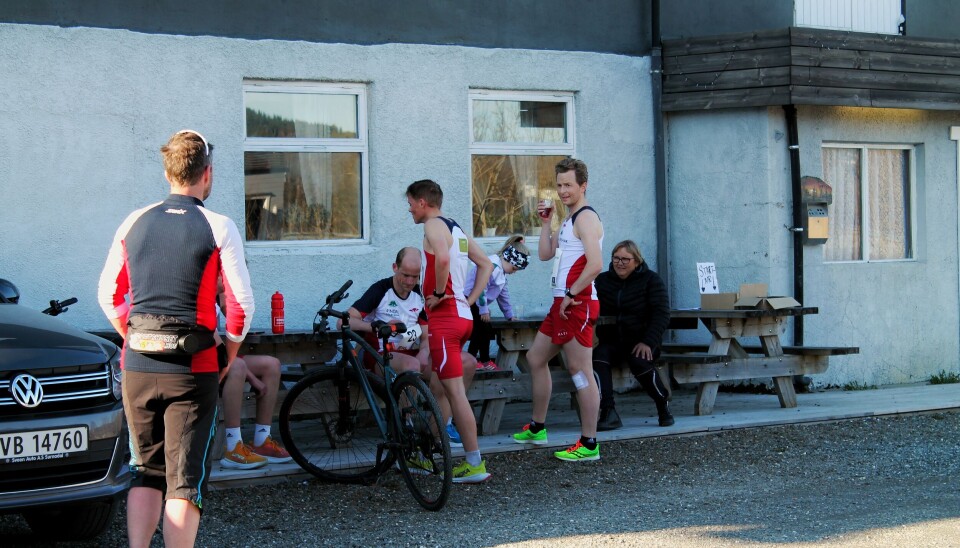 Løpere står ved benkene og drikker saft