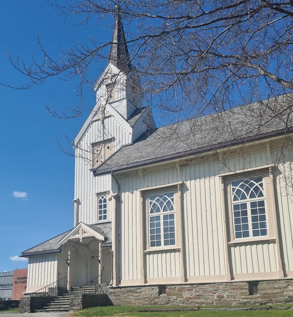 Øye kyrkje. En hvit trekirke og blå himmel