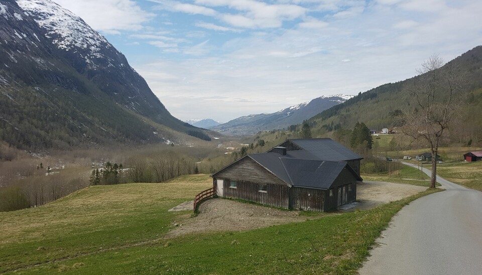 En hytte i en dal med nydelig utsikt med fjell på begge sider
