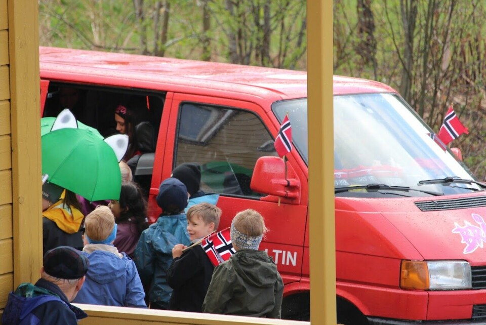 Barn står foran en rød russebil