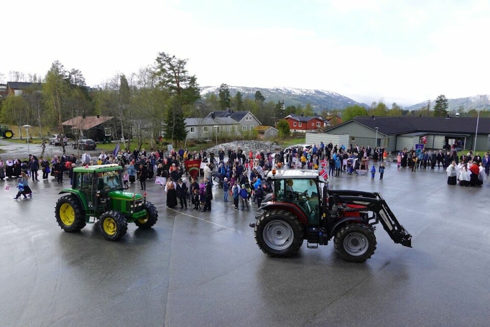 2 traktorer kjører foran en folkemengde