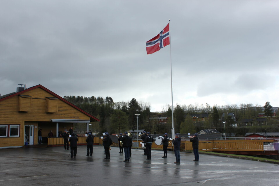 Korpset spiller ved flaggstanga med det heiste flagget