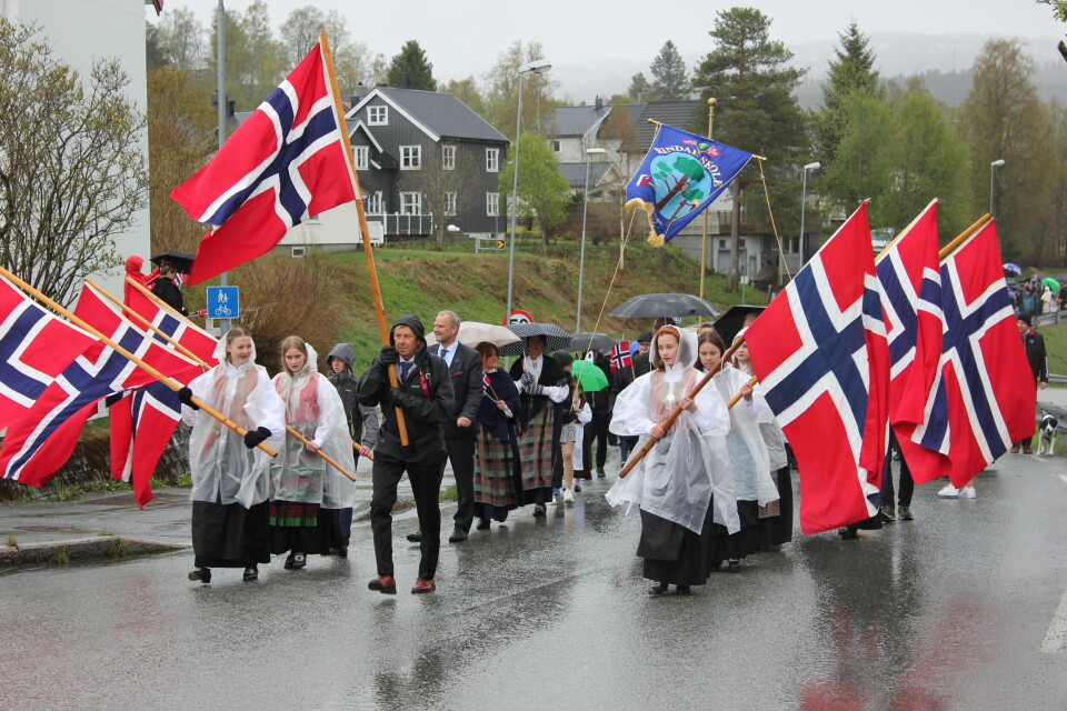 Store norske flagg holdes i luften når toget går oppover veien