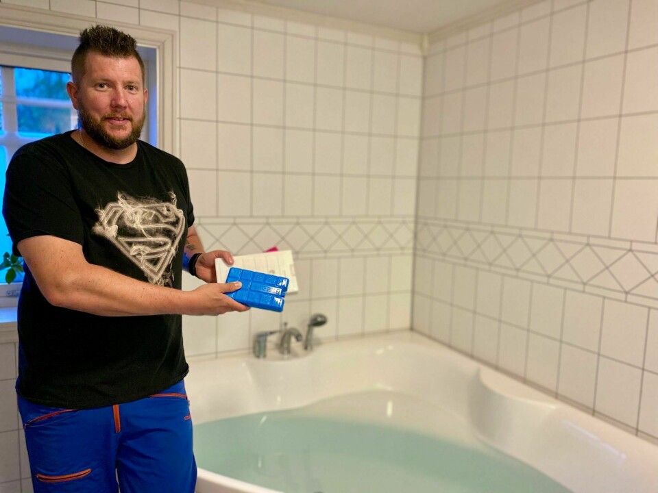 Daniel Bøe med kjøleelementer foran badekaret som har vært flittig i bruk.