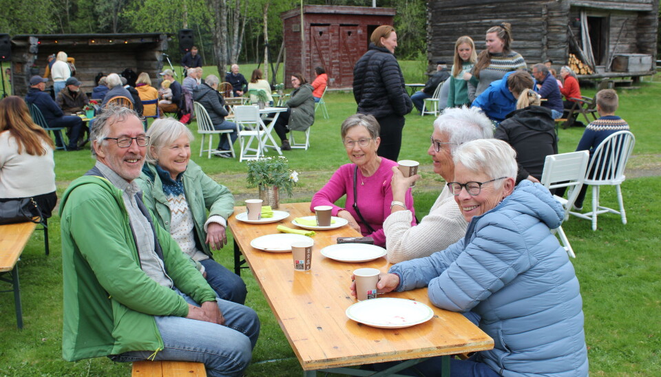 5 mennesker sitter på en benk med vafler og kaffe