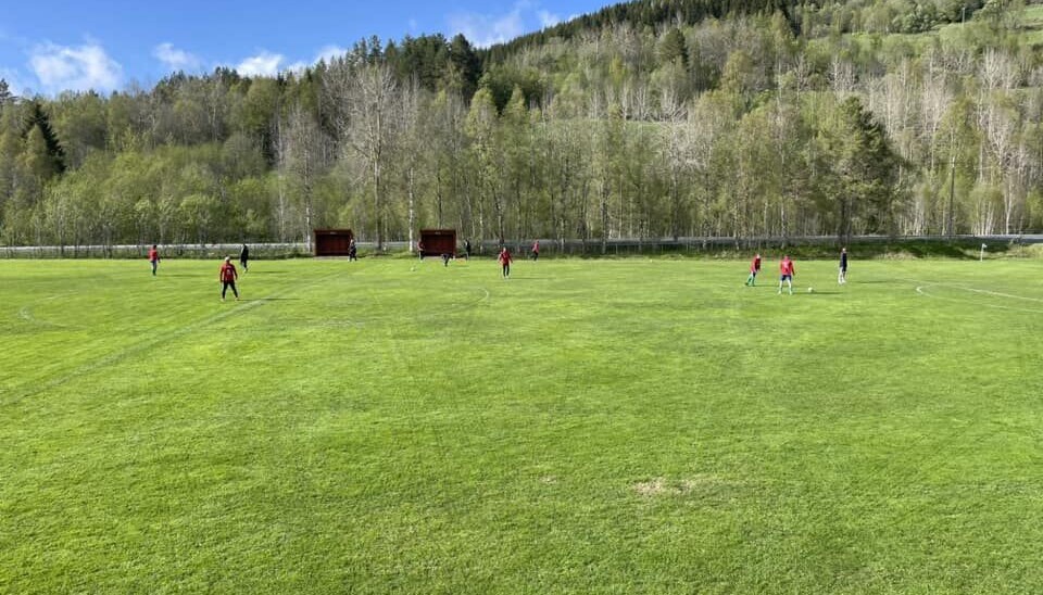 Rindal 2 varmer opp i solskinnet på hjemmebane. Rindal 2 og solskinn på en grønn hjemmebane.