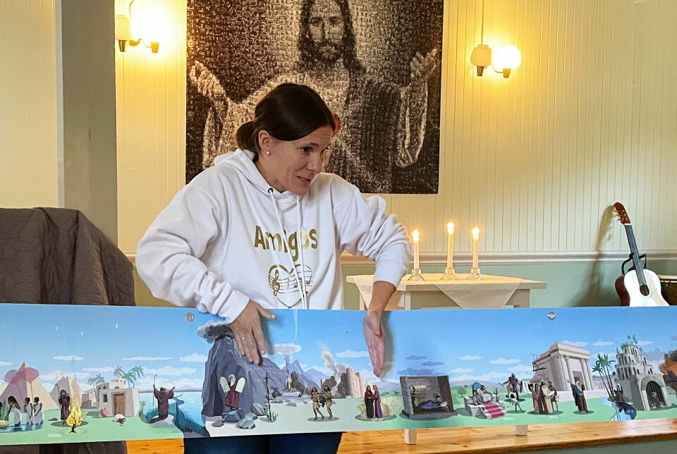 En kvinne holder en illustrajon i en kirke