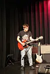 En gutt spiller gitar.