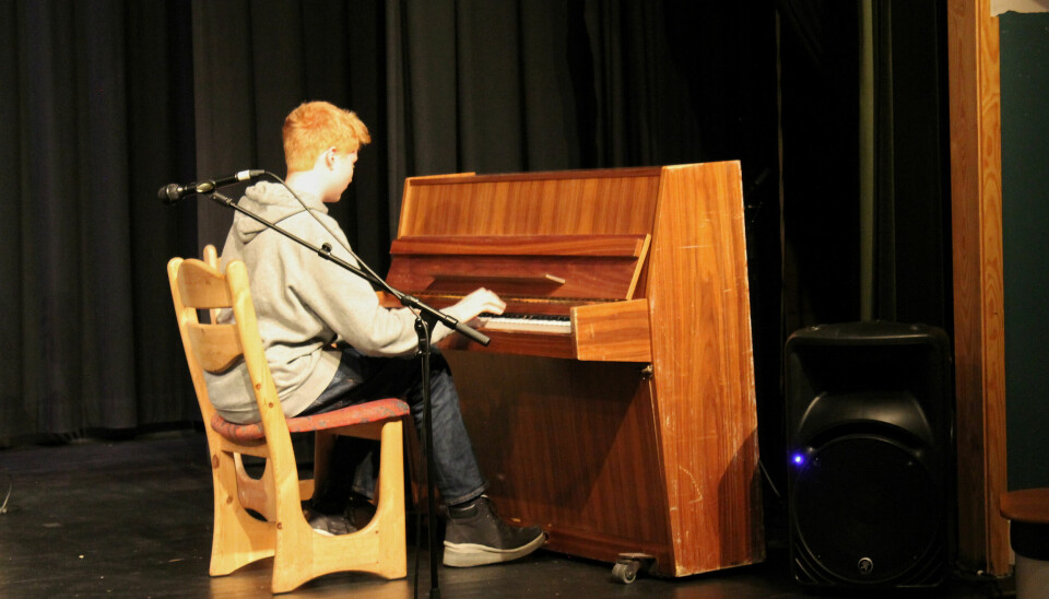 Gutt sitter og spiller på piano.