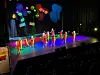 Barn kledd i klovnedrakter danser på scenen.