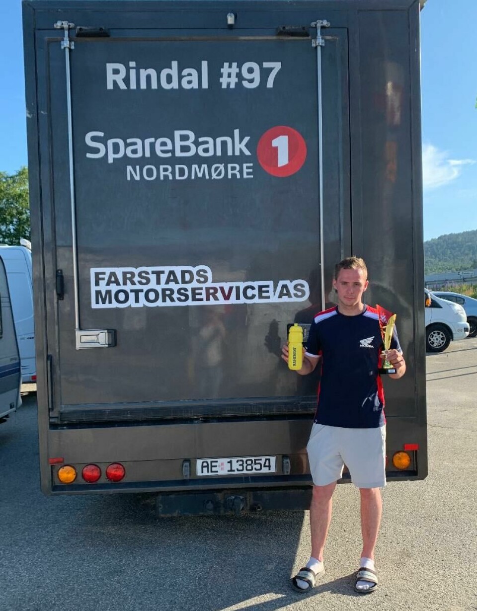 Mann foran en lastebil hvor det står 'Rindal #97', 'SpareBank1 Nordmøre' og 'Farstads Motorservice AS'