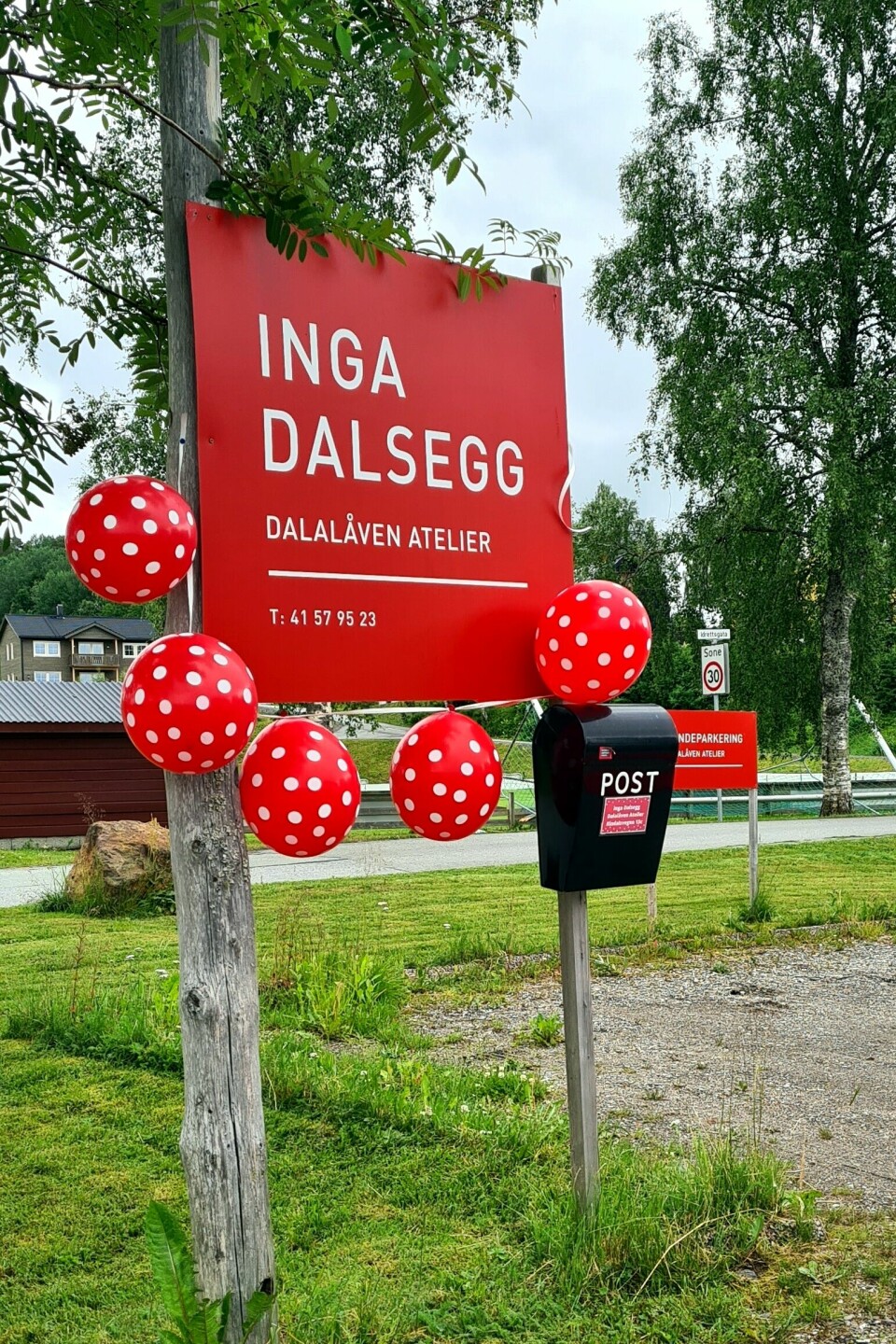 Raud plakat til Dalalåven pynta med raude kvitprikka ballongar