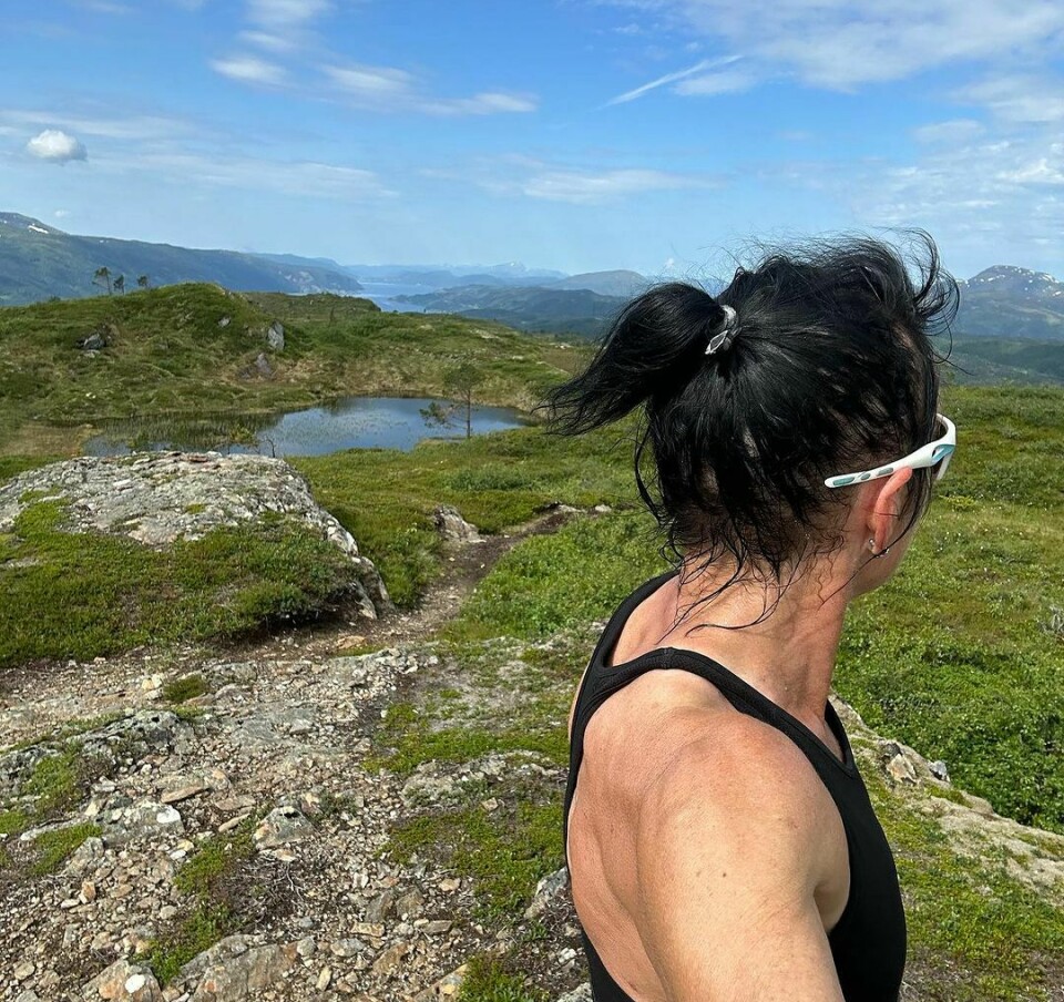 En kvinne står på et fjell og ser utover utsikten