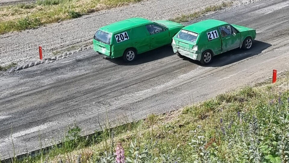 To grønne rallybiler kjører ved siden av hverandre.